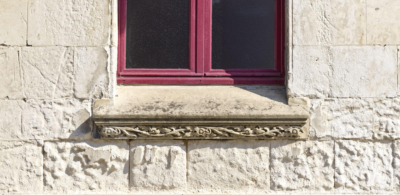 Détail du décor végétal néo-gothique de l'appui de fenêtre de la façade ouest du beffroi.