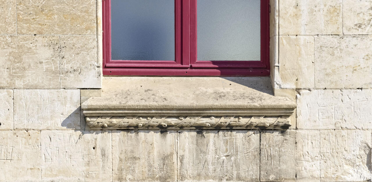 Détail du décor de branche en appui de fenêtre de la façade ouest du beffroi.