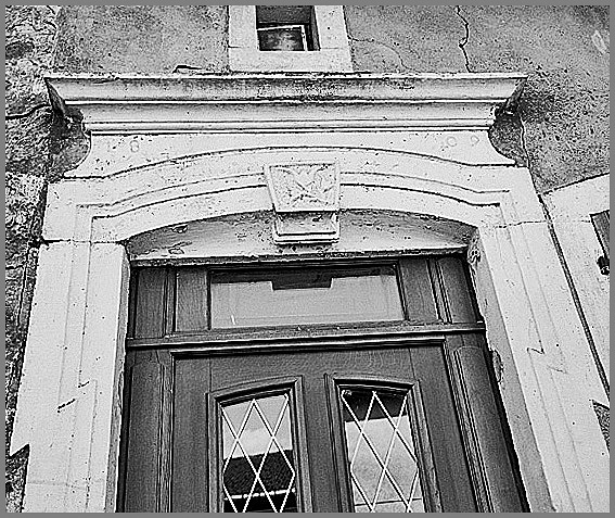 Ferme, élévation antérieure, porte piétonne, détail : décor agrafe et linteau daté 1803, ensemble.