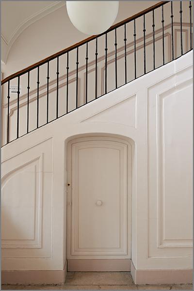 Escalier principal, mur d'échiffre et porte.