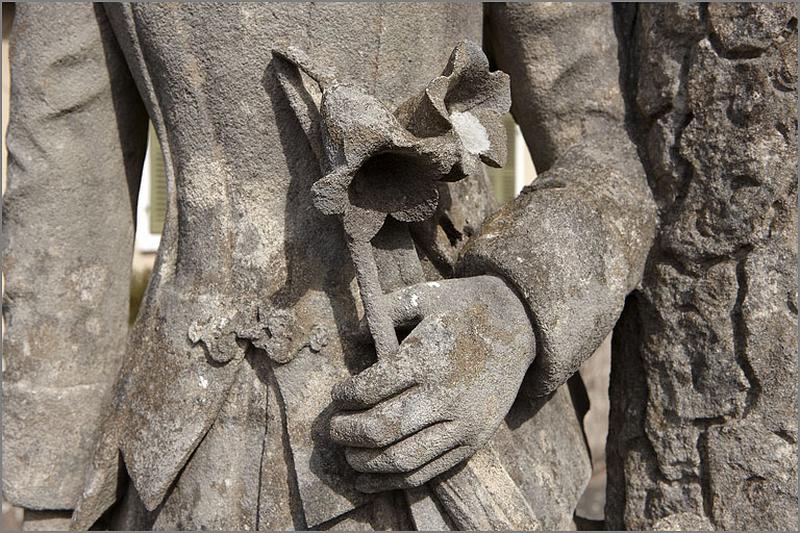 Stèle n° 2, détail de la statue : main gauche et lys