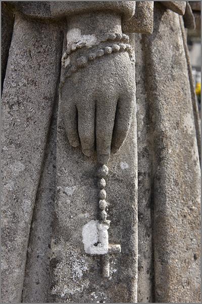 Stèle n° 2, détail de la statue : main droite et chapelet