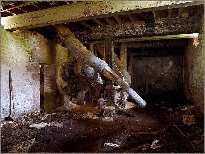Sous-sol, ancien embiellage du haut-fer et tuyaux d'aspiration de la sciure.