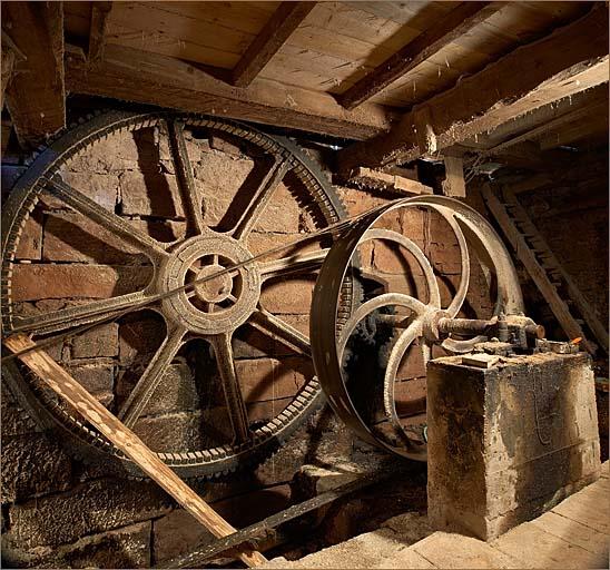 Sous-sol de la scierie, roue dentée et poulie d'entrainement du haut-fer.