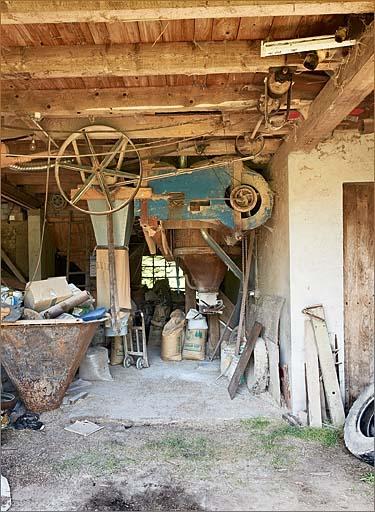 Bâtiments annexes, intérieur, van et ensachage du grain pour le bétail.