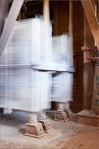 Intérieur de la minoterie, 1er étage, vue rapprochée du plansichter en fonctionnement.