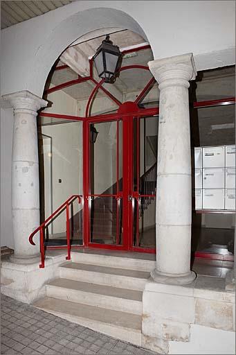 Passage couvert, détail (côté droit) : colonnes encadrant l'entrée de l'immeuble, trois quarts droit.