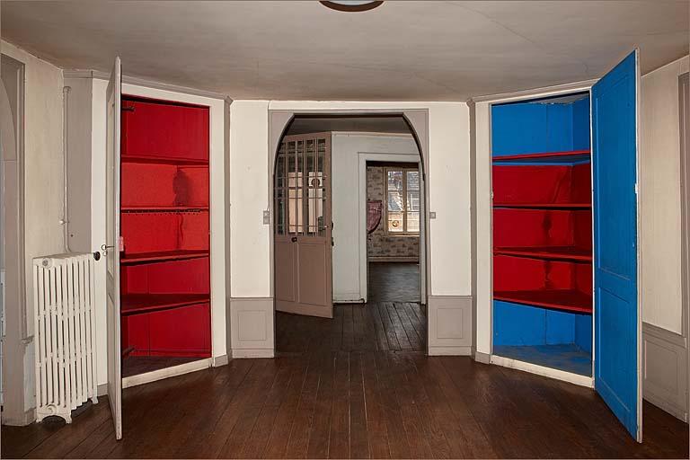 Pièce 2.2, vue d'ensemble vers entrée avec placards ouverts.