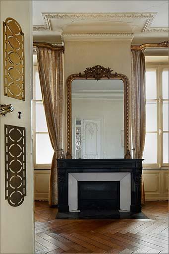 Cheminée avec glace de trumeau, lambris d'appui et décor de plafond.