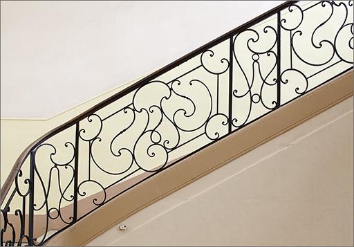 Corps B : escalier, rampe, détail du décor.