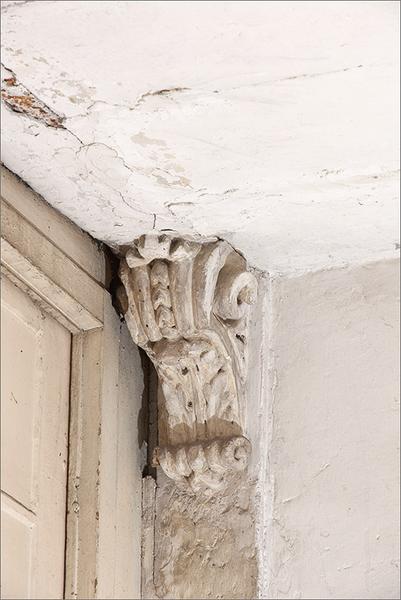 Première volée de l'escalier : détail console feuillagée palier intermédiaire.