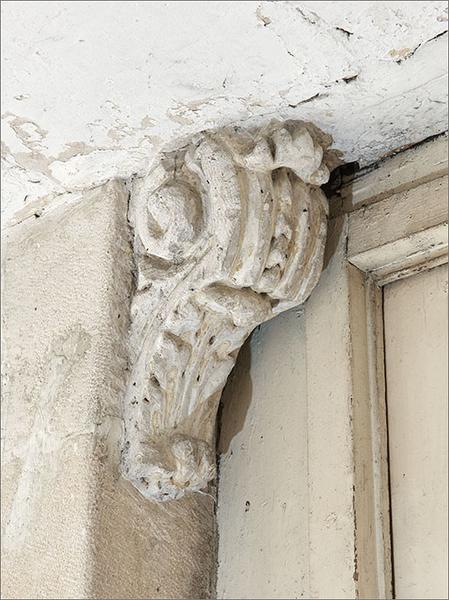 Première volée de l'escalier : détail console feuillagée palier intermédiaire.