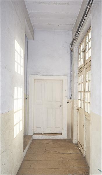 Palier deuxième étage : porte d'entrée corps A et porte-fenêtre sur cour principale.