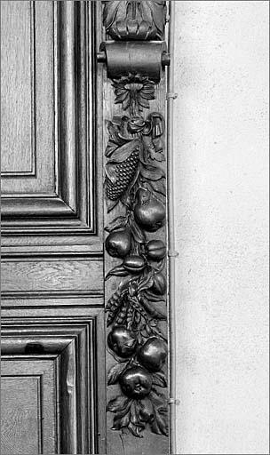 Détail d'une chute de fruits et légumes (poires, pommes, prunes, maïs, petits pois...) sous une corniche soutenant un musicien.