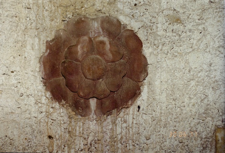 Vue de détail d'un élément sculpté, encastré dans le clocher.