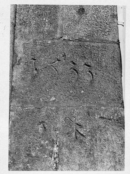 Détail du contrefort d'angle : millésime et signe lapidaire.