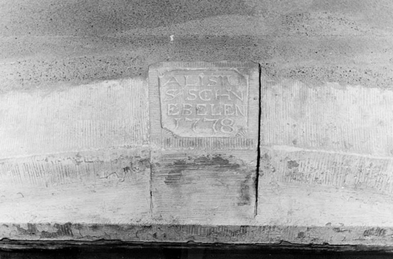 Vue de détail : inscription sur le linteau de la porte d'entrée du logis.