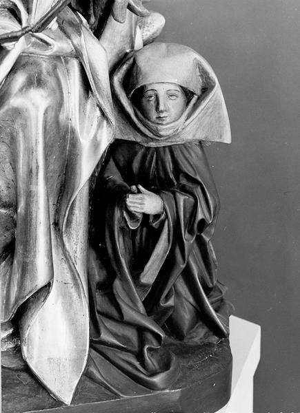 Statue de Saint Thiébaut et deux pèlerins, détail de la pèlerine agenouillée vue de face.