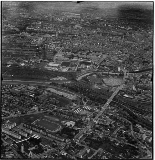 Vue aérienne : la ville vue du nord. Bourtzwiller au premier plan, le musée de l'Automobile à droite après le pont du chemin de fer, la Cité Jean Wagner au centre.