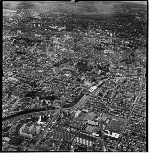 Vue aérienne : la ville vue du nord. C.E.T. et le canal de dérivation au premier plan, le centre ville de l'autre côté.