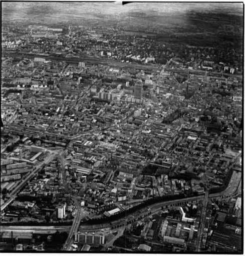 Vue aérienne : la ville vue du nord. Le canal de dérivation est au premier plan, l'avenue de Colmar est à droite jusqu'à la tour de l'Europe, le centre ville est en haut à droite.