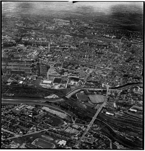 Vue aérienne : la ville vue du nord. Bourtzwiller au premier plan, le cimetière à gauche, le centre ville à droite.