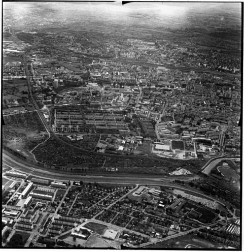 Vue aérienne : la ville vue du nord. Bourtzwiller au premier plan, le cimetière au-delà du canal de dérivation.