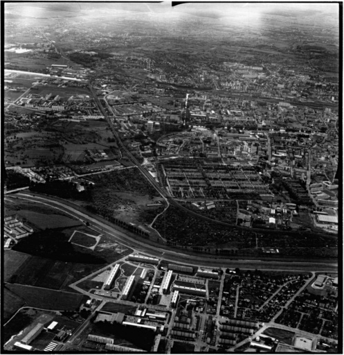 Vue aérienne : la ville vue du nord-est. Bourtzwiller au premier plan, le cimetière au centre et le quartier Drouot en haut à gauche.