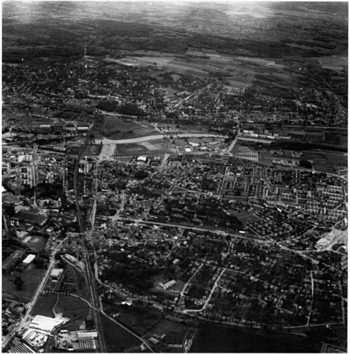 Vue aérienne : la ville vue du nord, au premier plan la colline de Dornach, à l'arrière le quartier de Bel-Aire.