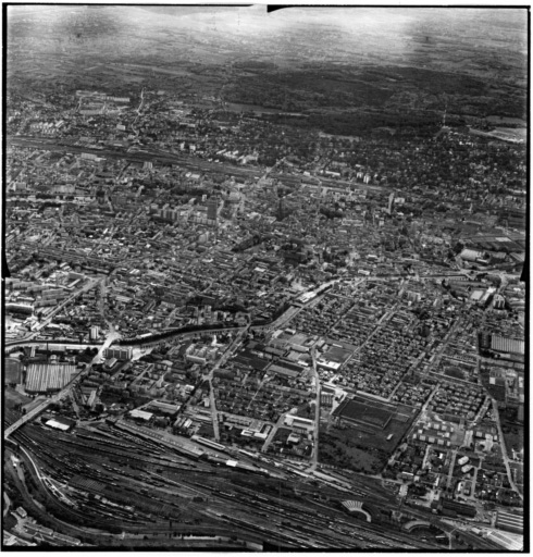 Vue aérienne : la ville vue du nord : gare du nord au premier plan, filature de laine peignée Gluck et Cité à droite.