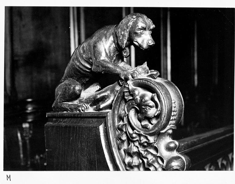 Mur nord, stalles basses, 1er groupe, parclose 1 (ouest) : statuette d'un chien, ajoutée lors de la restauration de 1900.