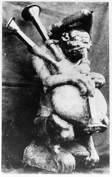 Façade principale donnant sur la rue : échanguette : statue du singe jouant de la cornemuse.