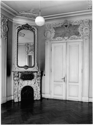 Salon au rez-de-chaussée, pièce centrale du côté sud-est : porte nord-ouest donnant sur le vestibule et cheminée dans l'angle ouest.