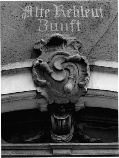 Elévation sur rue : détail de l'emblème au-dessus de la porte d'entrée.