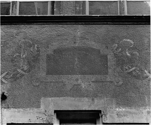 Elévation sur rue : détail d'un cartouche peint au-dessus de la fenêtre centrale du premier étage.