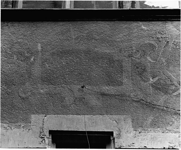 Elévation sur rue : détail d'un motif peint au-dessus de la fenêtre de gauche au premier étage.