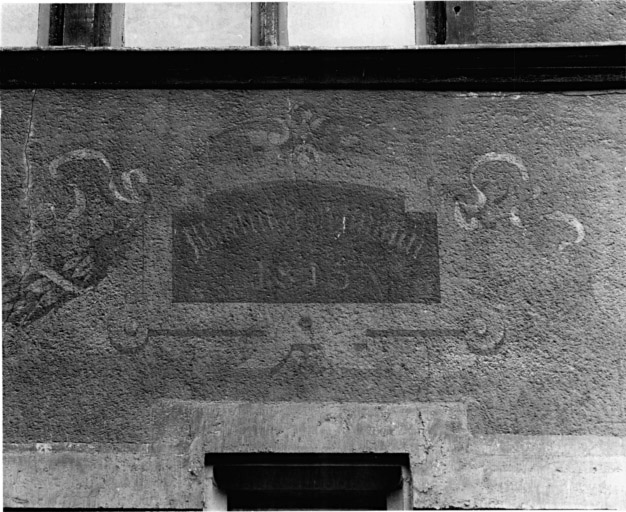 Elévation sur rue : détail d'un cartouche peint au-dessus de la fenêtre à droite au premier étage.