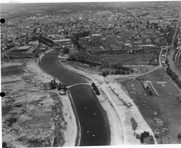 Vue aérienne de la ville depuis le sud avec l'Ill à gauche le canal du Rhône au Rhin : au centre l'usine de la S.A.C.M.