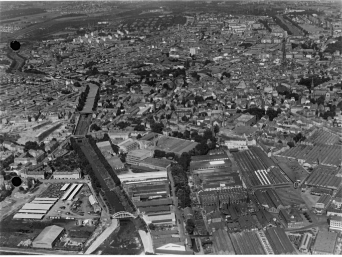 Vue aérienne du sud avec le canal de dérivation à gauche et l'usine de la S.A.C.M. au premier plan.