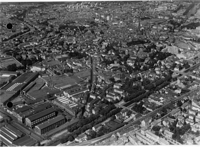 Vue aérienne prise du sud avec l'usine S.A.C.M. à gauche, la rue du Manège et la rue Kléber au centre, le canal du Rhône au Rhin à droite.