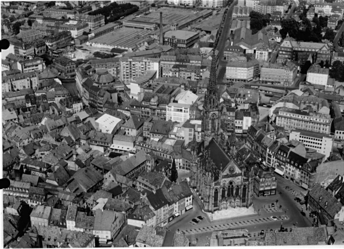 Vue aérienne de la vieille ville, avec le temple Saint-Etienne au premier plan, l'usine de la Dentsche au fond.