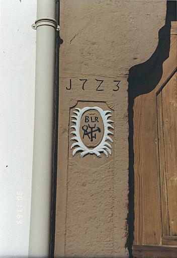 Hôtel ' Au Lion Rouge ', 29 rue des Seigneurs. Emblème de forgeron, daté 1723, vestige de la maison antérieure, sur un encadrement de porte.