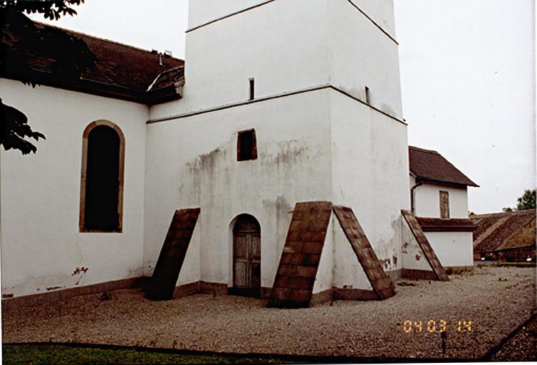 La base de la tour épaulée par quatre contreforts.