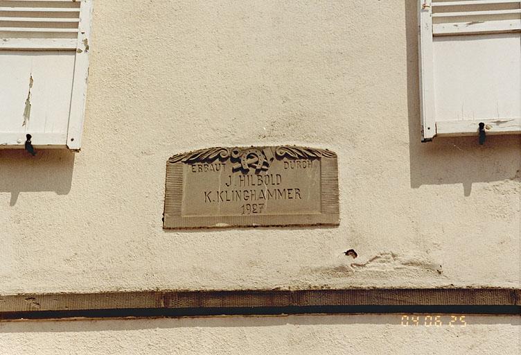 Vue d'une maison de maréchal ferrant 22 rue Louis Pasteur, inscription dans le pignon avec l'emblème et la date 1927.