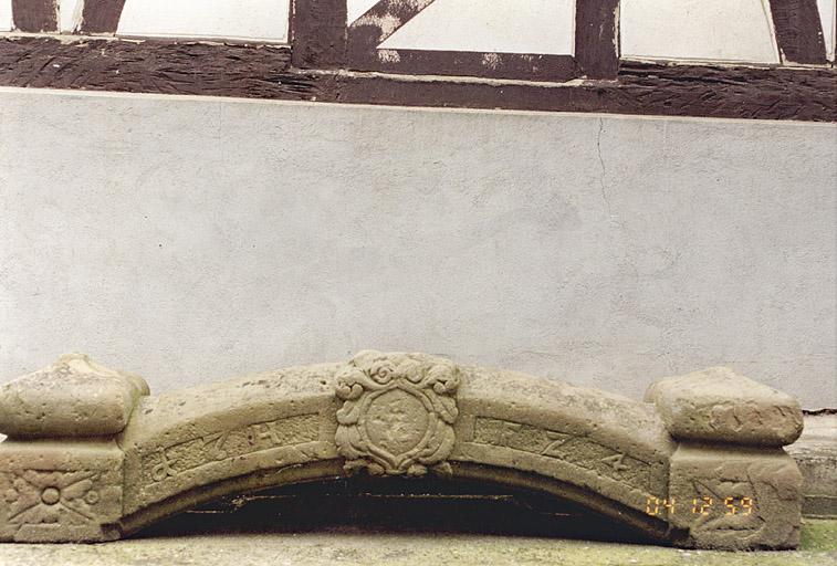 Le linteau de porte piétonne, souvenir de l'ancienne ferme.