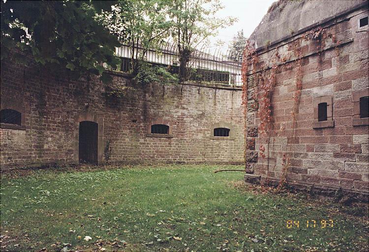 Le fossé de caponnière Ouest. A remarquer : les pierres de taille à bossage du socle et des chaînes d'angle de toutes les élévations proviennent des fortifications démantelées de Phalsbourg.