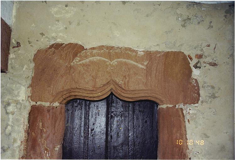 Maison antérieure nord. Détail de la porte sous le passage d'entrée avec écus bûchés.