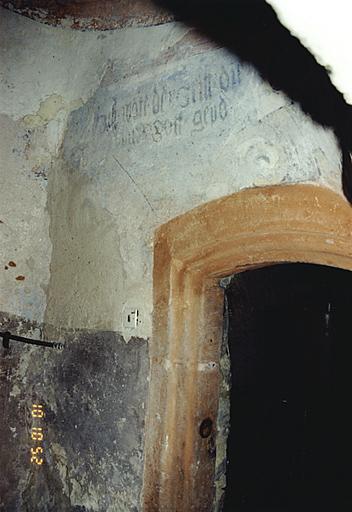 Corps de bâtiment ouest avec tourelle d'escalier dans-oeuvre, de 1577. Détail d'une porte intérieure vers la maison nord et décor peint avec inscription pieuse.