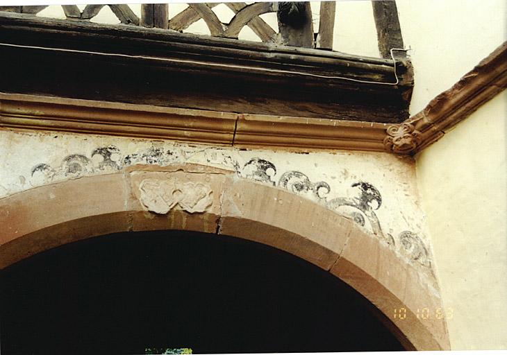 Maison sud. Détail de l'élévation nord et du cordon avec tête sculptée, faisant retour sur la le corps de bâtiment ouest.