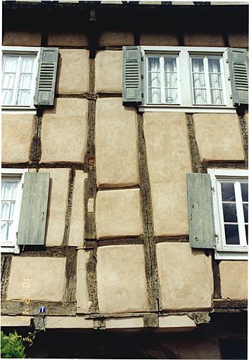 Elévation antérieure. Vue partielle du pan de bois de l'étage et du pignon avec poteaux d'un seul tenant et traces de remaniements.
